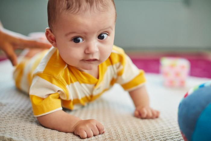 Ребенок лежит на животе. Вертикальное положение после кормления поможет избежать рефлюкса у младенцев